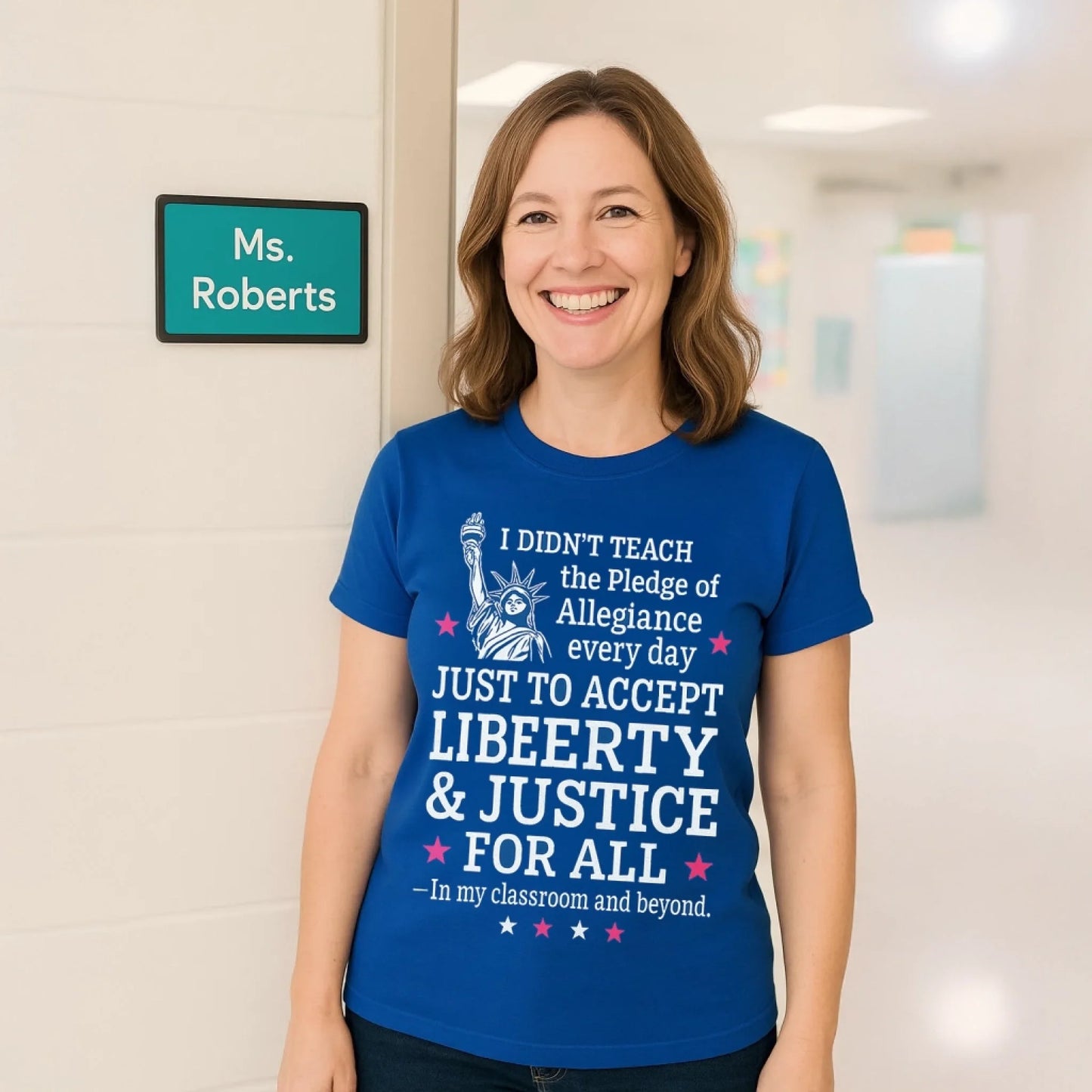 Cheerful female teacher in a bright hallway wears a royal blue shirt with the quote TEACH LOVE INSPIRE, standing beside a white classroom wall with a teal nameplate labeled Ms. Roberts