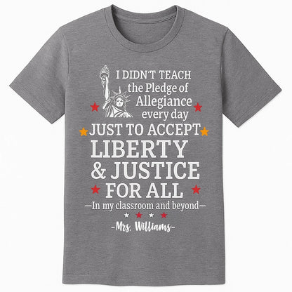 heather T-shirt featuring a bold white and red graphic of the Statue of Liberty and the quote I didnt teach the Pledge of Allegiance every day just to accept anything less than liberty justice for all — In my classroom and beyond.